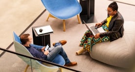 Man and woman sitting and working in a lounge area